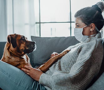 Dog with woman wearing mask