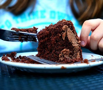 girl eating chocolate cake with a fork