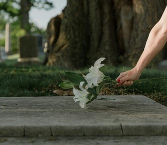 Woman in a cemetery setting lilies on a grave
