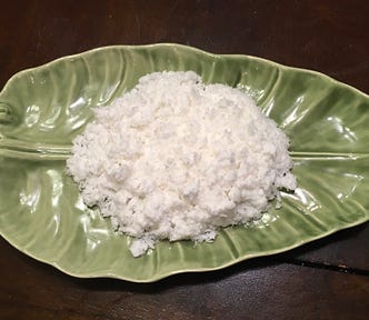 White coconut shavings on a green plate.