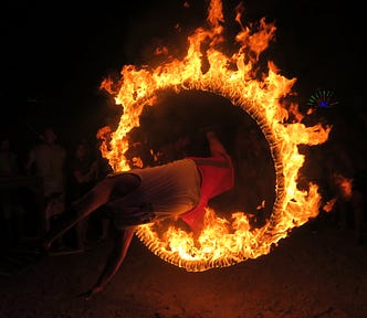 A festival-goer jumps through a fire hoop at the Full Moon Party in Koh Phangan, Thailand.