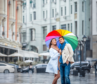 Couple in love standing under an umbrella in the rain