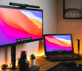 Back lit desk with a laptop and monitor