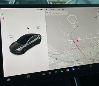 A photo of the center display in a Telsa Model 3 with the author’s prototype displayed