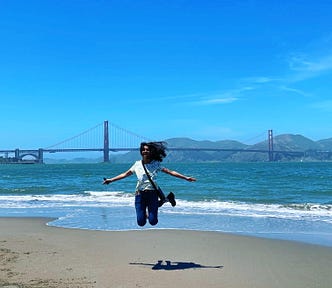 Anupriya against the backdrop of Golden Gate bridge and beach in San Francisco