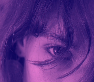 Close-up of two eyes,through messy hair. Photo edited in a purple tint.