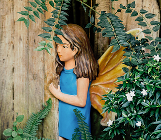 A wood carving of a fairy in a magical door, peeping out.