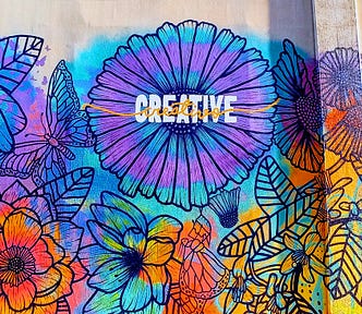 Colorful wall mural featuring flowers in Riverside CA with the word Creative