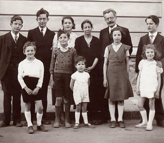 Black and white image of a large family taken a few decades ago.