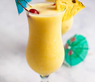 Pina colada cocktail with cherries and paper umbrellas