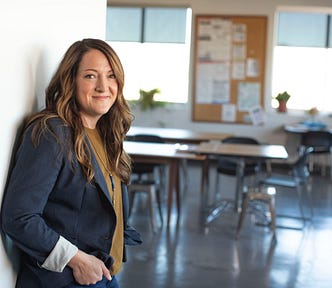 Photo of a woman in an empty office space smiling fondly