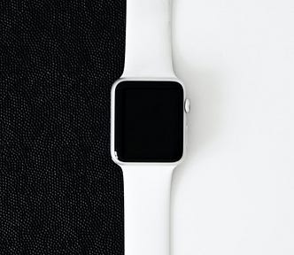 An apple watch sitting on the top of a black cloth photo