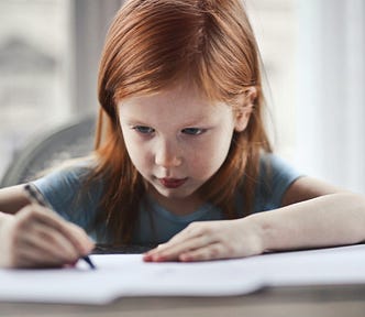 A little girl writing on paper