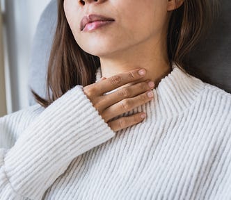 Photo of a woman putting her hand to her collarbone