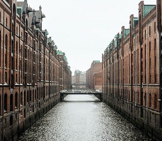 symmetrical buildings across a canal and a sky with no clouds