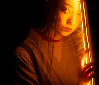 Closeup of woman in illuminating light.