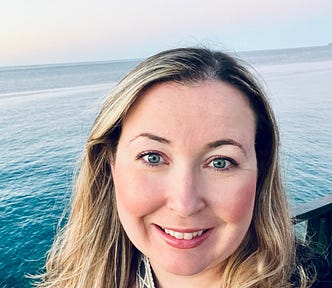 picture of author smiling with the ocean in the background