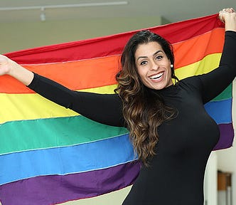 DIGTRANS coordinator Melissa Venezian holds up a rainbow flag