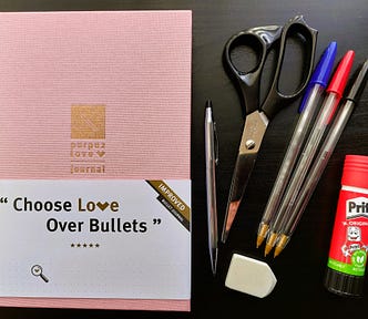 Image shows a pink bullet journal on the left, and on the right three pens, scissors, a silver pencil, glue and an eraser.