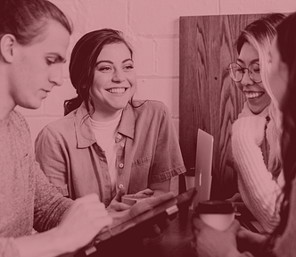 Four people standing around a table, smiling