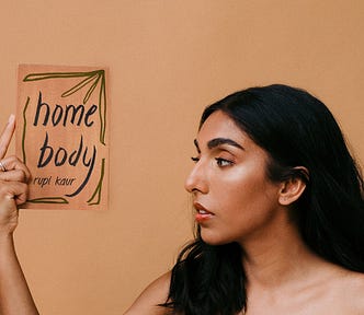 Poet Rupi Kaur holding her newest poetry book, Home Body