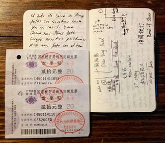 An open Moleskine notebook, notes, a small hand-drawn map with directions and 2 tickets for some means of transportation in China