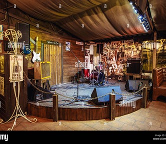 A small stage in a bar, with musical instruments on it.