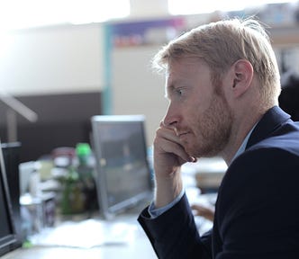 Man staring at computer screen in office