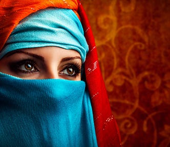 Woman in Hijab, red background. Hijab is turquoise blue.