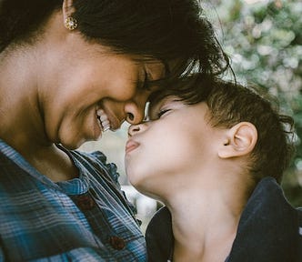 Mother and child smiling and touching noses with each other