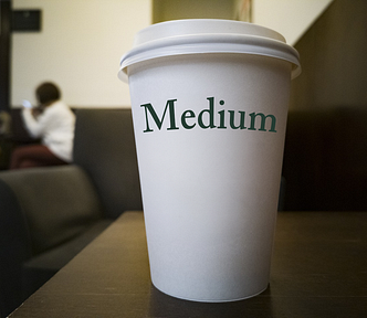 A carry out coffee cup labelled “Medium” (Demystifying writing on Medium.com)