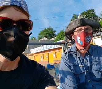 The author and her husband in covid masks in the back of a pickup truck