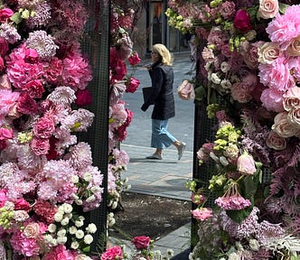 mirror reflection of a woman walking by and floral arch | © pockett dessert, blooms