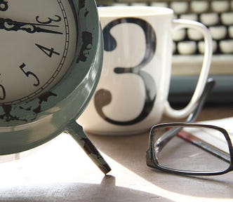 A clock, a coffee, and glasses