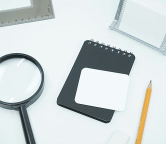A magnifying glass and notebook