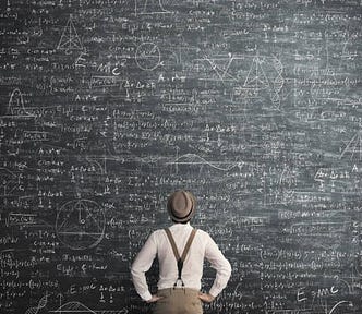 Man looking up at complex scribbles on Blackboard