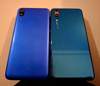 Two old smartphones lying side by side on a table.