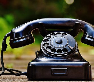 Old school black body round number dial-in telephone.
