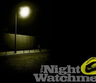 Man standing under a lamppost at night with the Night Watchmen logo under the street scene