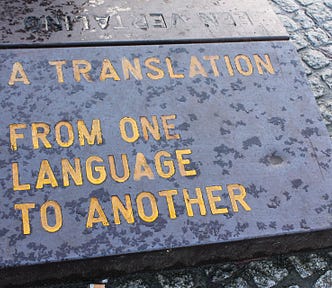 Black stone slab with an engraved phrase, “A translation from a language to another.”