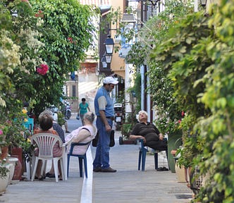Cretans sitting over a drink in an alleyway in Rethymno, Crete
