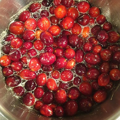 Bright red cranberries, in the process of being made into cranberry sauce.