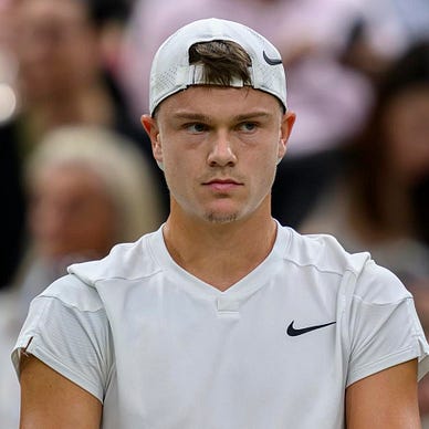 Photo of Holger Rune from his shirt up with a intense look between games at Wimbledon.