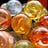 a group of orange, yellow, and blue colored glass marbles