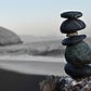 Grey pebbles stacked on top of each other with grey toned beach scene behind