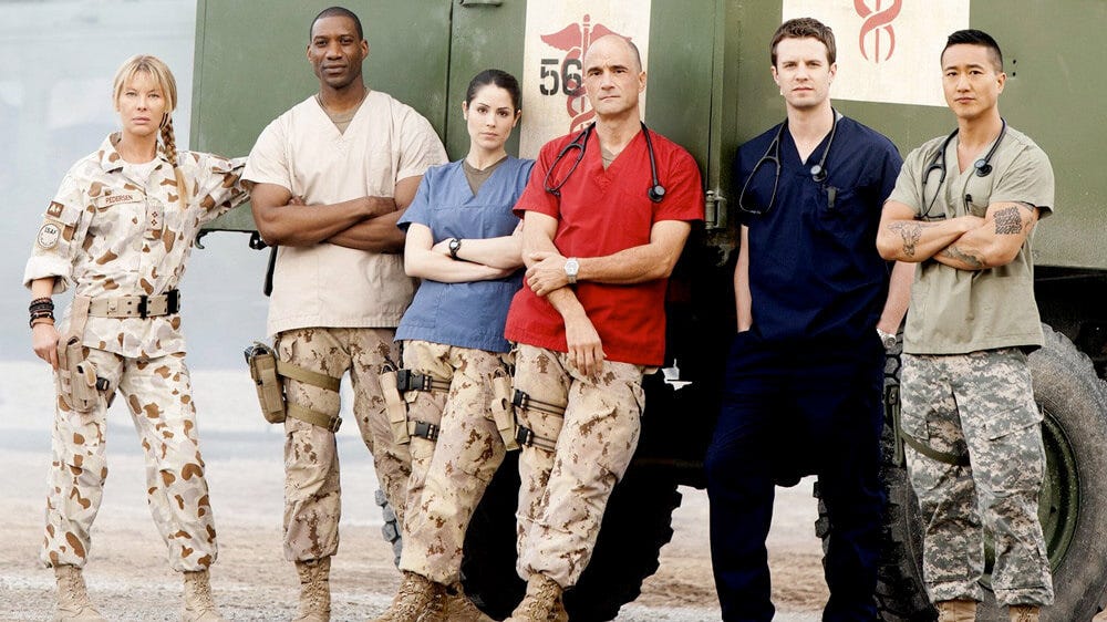 The main characters of the TV series Combat Hospital. In the red smock, is Elias Koteas, the actor playing me. The scriptwriters even named his wife Christine. Thanks for the honour. Much appreciated. Source : Ecmund Butt.