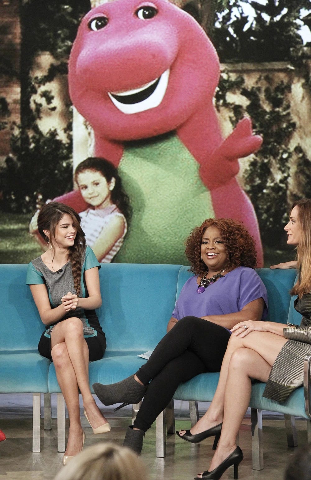 An image of Barney the Dinosaur and a young Selena Gomez flashes on screen during Gomez’s time on “The View” (October 2013).