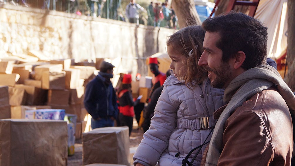 Alfonso ayudaba ilusionado a su hija Nerea a buscar su nombre entre los cientos de paquetes apilados por los pajes reales antes de ser entregados esa misma noche.