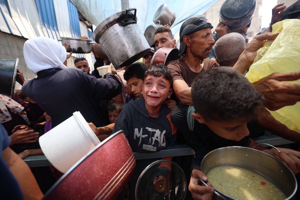 Palestinian children wait for food at a distribution point in Nuseirat, in the central Gaza Strip, on June 11, 2025. Israel has faced growing condemnation over the humanitarian crisis in the war-ravaged Gaza Strip, where the United Nations has warned the entire population faces the risk of famine after no aid was allowed to enter for more than two months. (Photo by Eyad BABA / AFP)