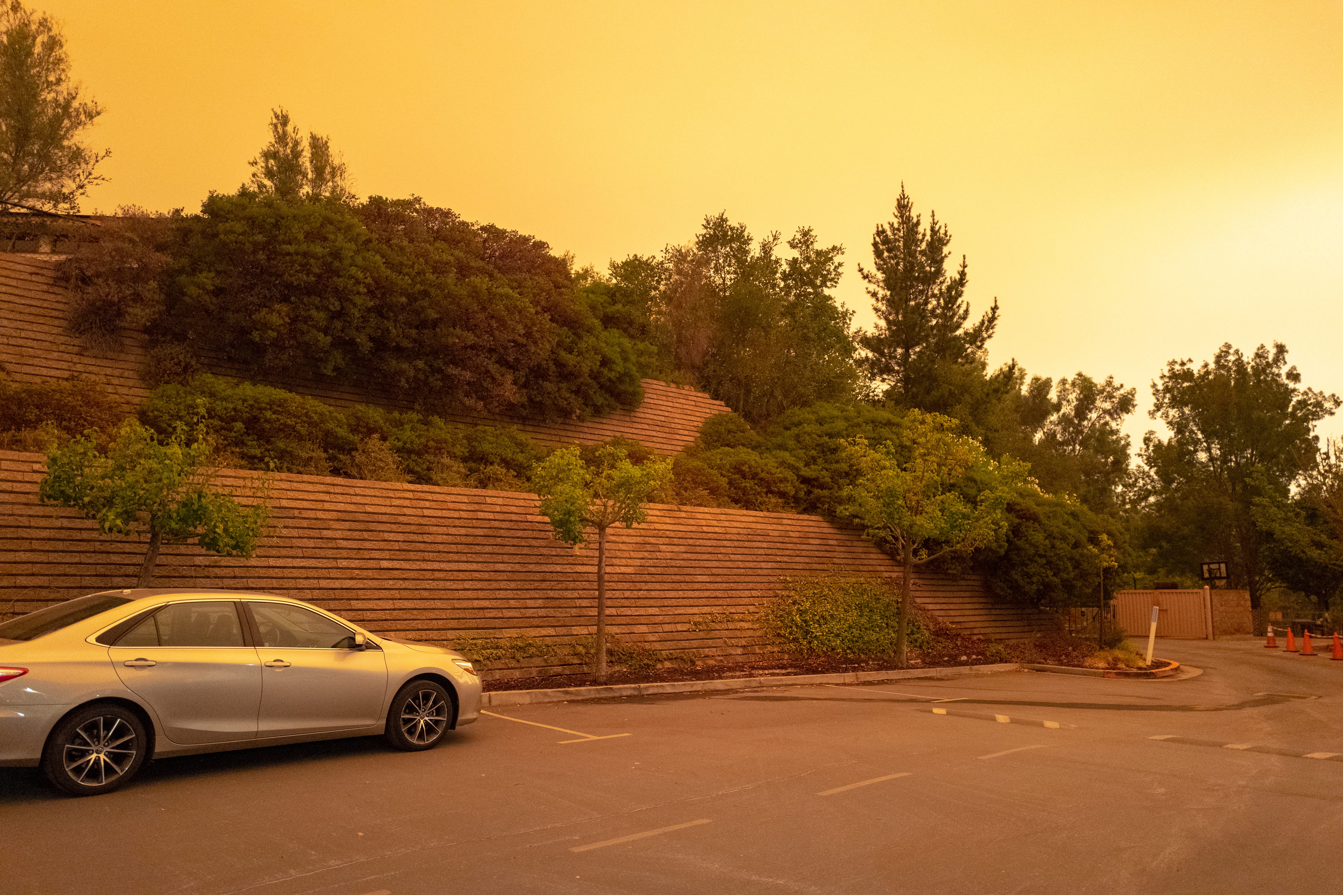 A parking lot under an orange, smoke-filled sky.